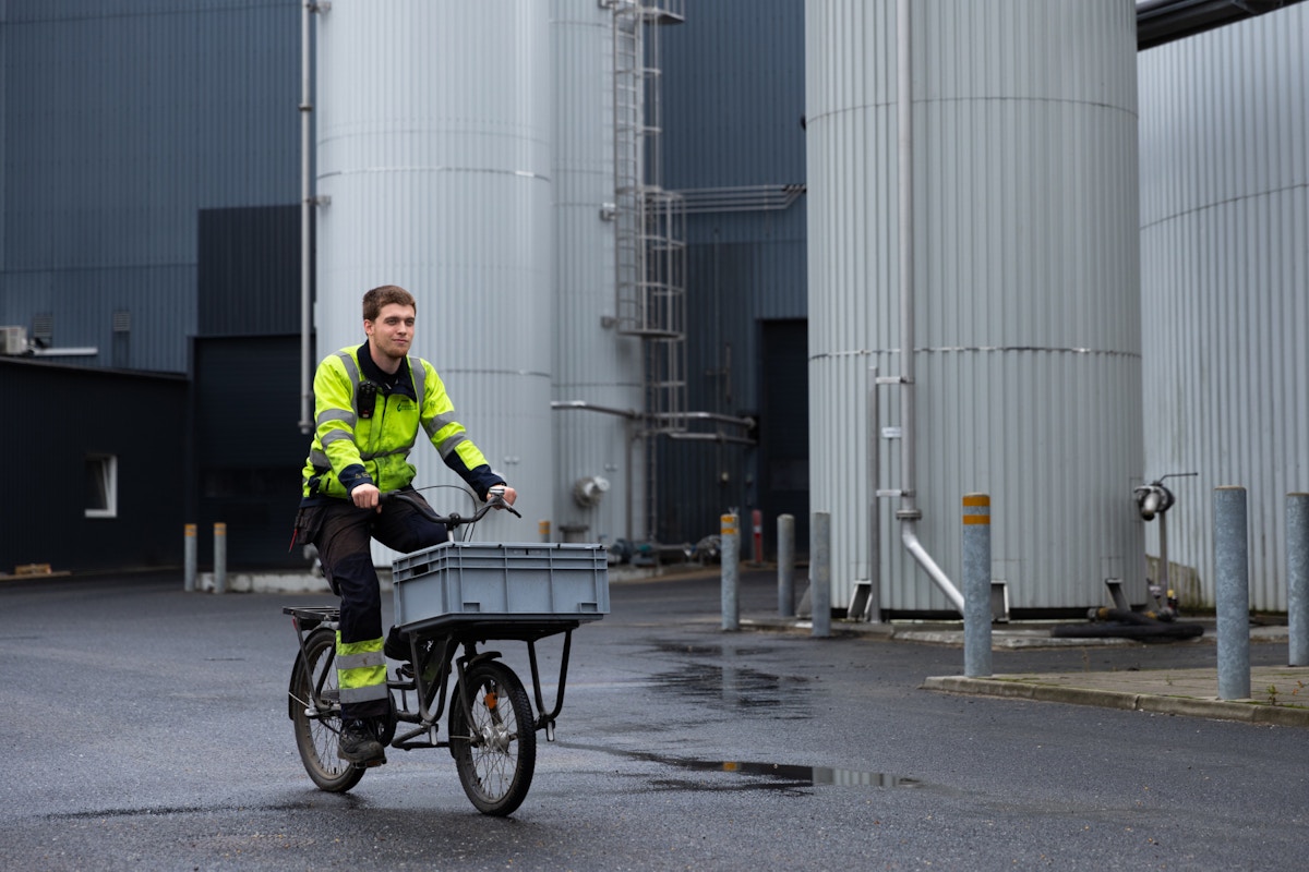 Employee riding a bike on a biogas Plant